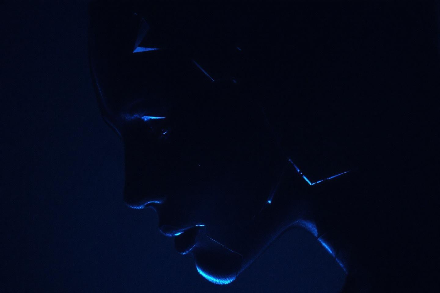 Profil sombre illuminé par des reflets bleus luminescents