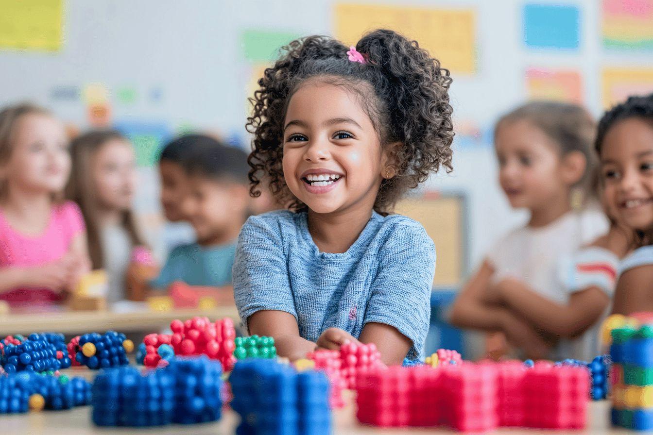 Petite fille souriante avec des blocs color&eacute;s en classe