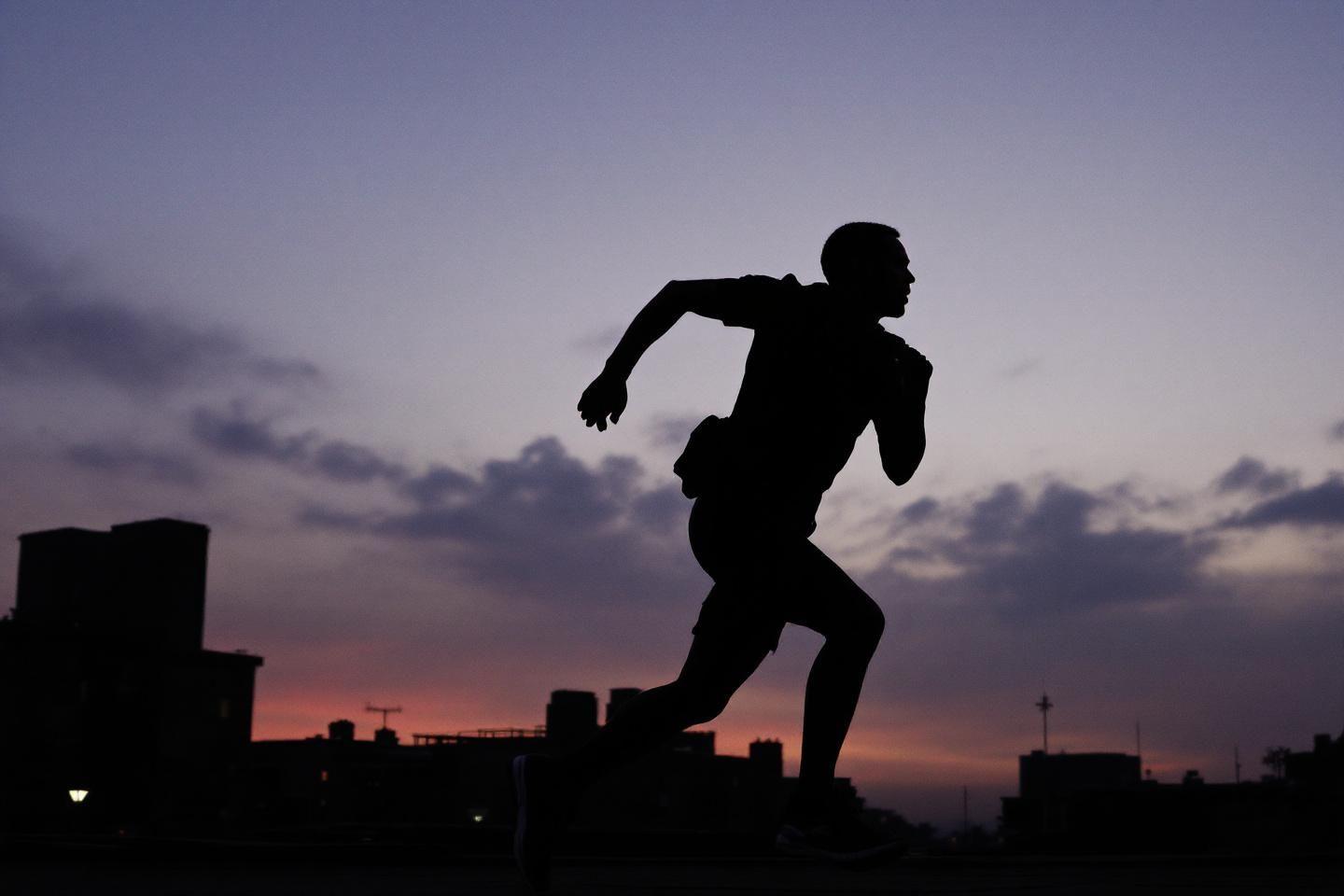 Silhouette d'un coureur en mouvement contre un ciel nocturne