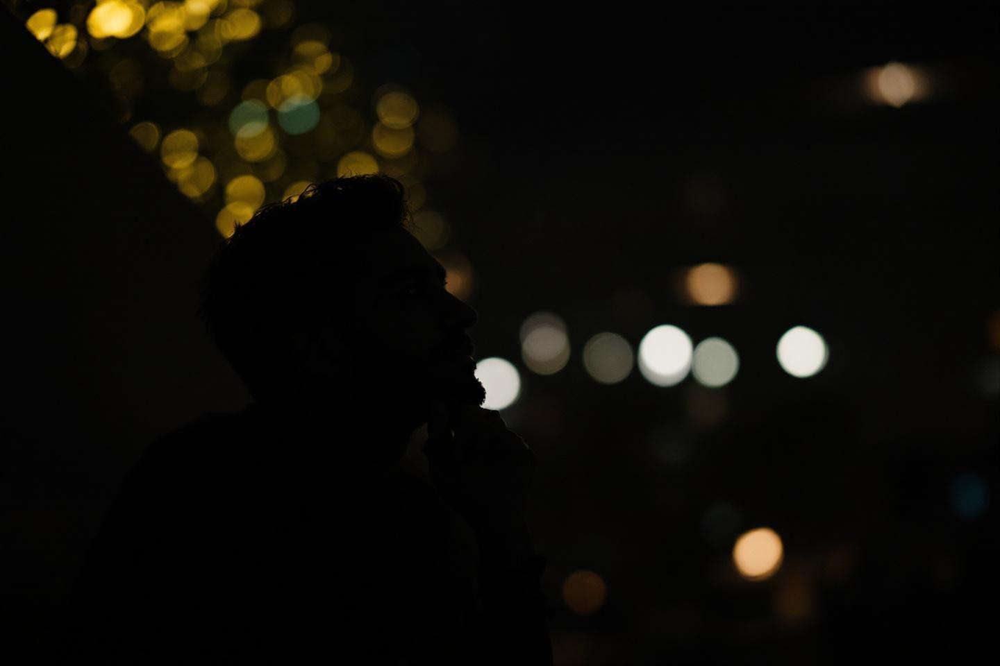 Silhouette sombre avec des points lumineux color&eacute;s en arri&egrave;re-plan