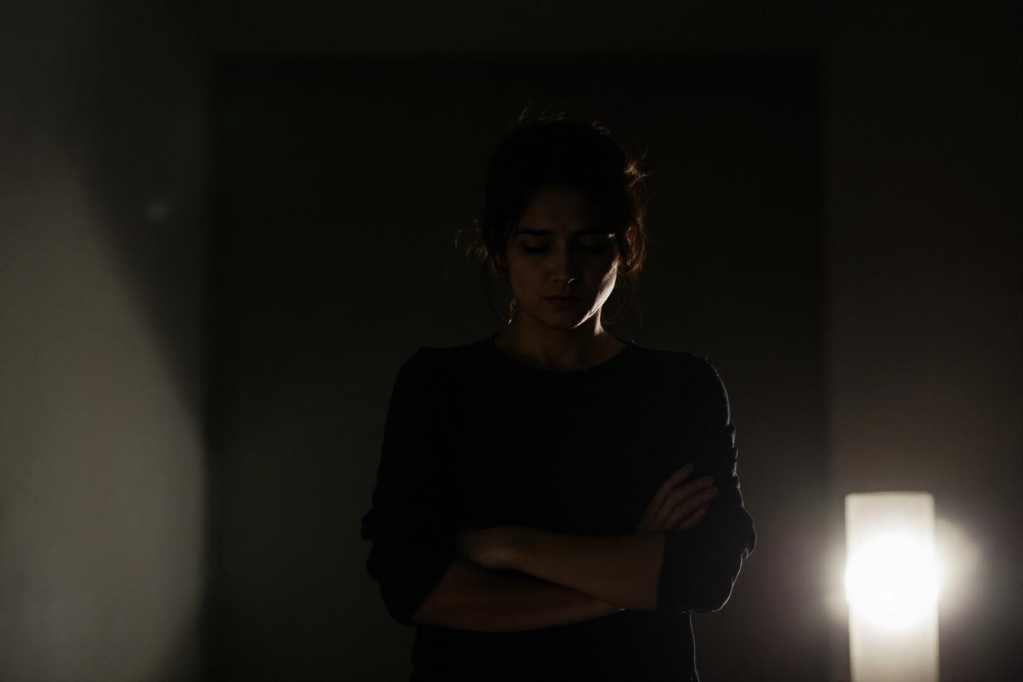 Silhouette sombre d'une personne les bras crois&eacute;s