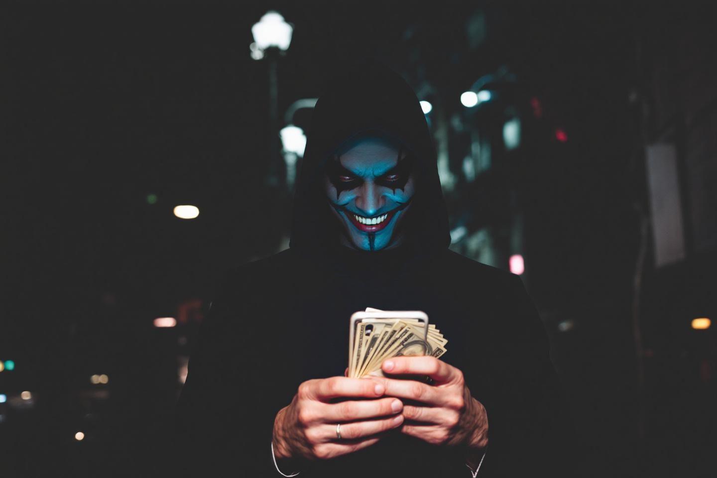 Personnage masqu&eacute; avec un sourire inqui&eacute;tant tenant des billets