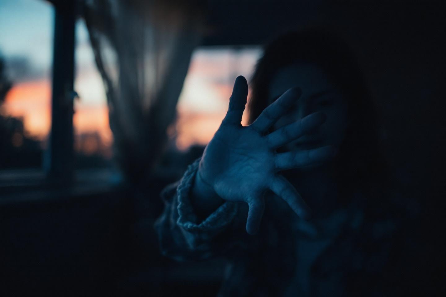 Main sombre et floue près d'une fenêtre au crépuscule