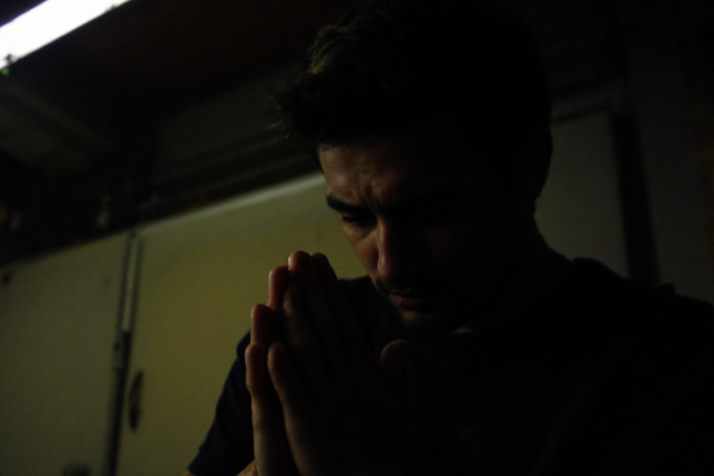 Silhouette sombre d'une personne en position de prière