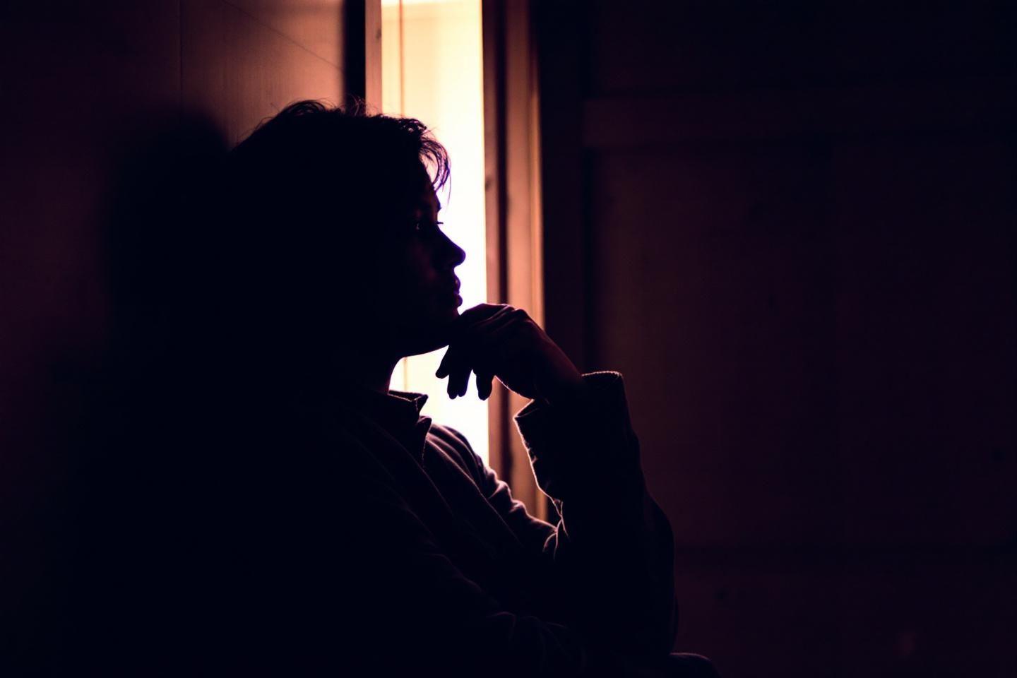 Silhouette sombre réfléchissant près d'une source lumineuse